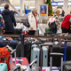 Travelers search through mountains of luggage at the baggage claim at Chicago Midway International Airport on Dec. 26, 2022, in Chicago.